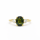 large green sapphire engagement ring with round accent lab grown diamonds on a white background
