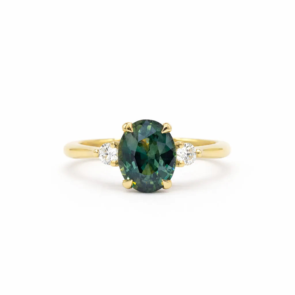 Gold ring with a greeny teal blue gemstone and smaller diamonds on a white background