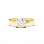 A chunky yellow gold engagement ring with a cushion-cut diamond set in a four-prong setting, photographed against a seamless white background.