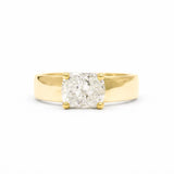 A chunky yellow gold engagement ring with a cushion-cut diamond set in a four-prong setting, photographed against a seamless white background.