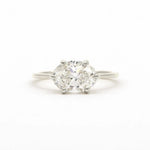 A classic solitaire engagement ring featuring an oval brilliant-cut diamond set east-to-west with four-prongs in a white gold or platinum band, centered on a seamless white background