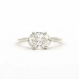 A classic solitaire engagement ring featuring an oval brilliant-cut diamond set east-to-west with four-prongs in a white gold or platinum band, centered on a seamless white background