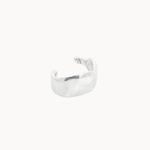 Silver ear cuff with organic texture on a white background