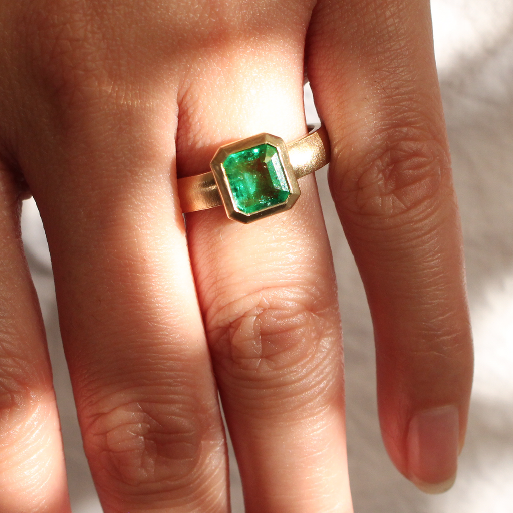 Emerald solitaire wide band engagement ring