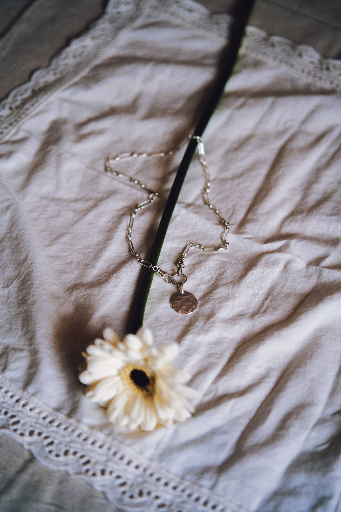 Necklace with a pendant on a textured fabric surface