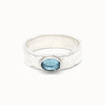 Silver topaz ring with a blue gemstone on a white background