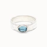 Silver topaz ring with a blue gemstone on a white background
