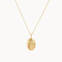 gold gemini necklace with oval pendant on a white background