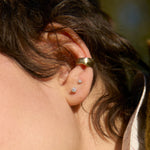 close up of ear wearing lucky gold ear cuff and diamond stud earrings