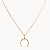 Gold necklace with a horseshoe pendant on a white background