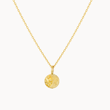 Gold necklace with a round moonlight engraved pendant on a white background