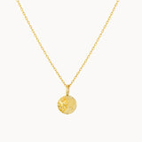 Gold necklace with a round moonlight engraved pendant on a white background