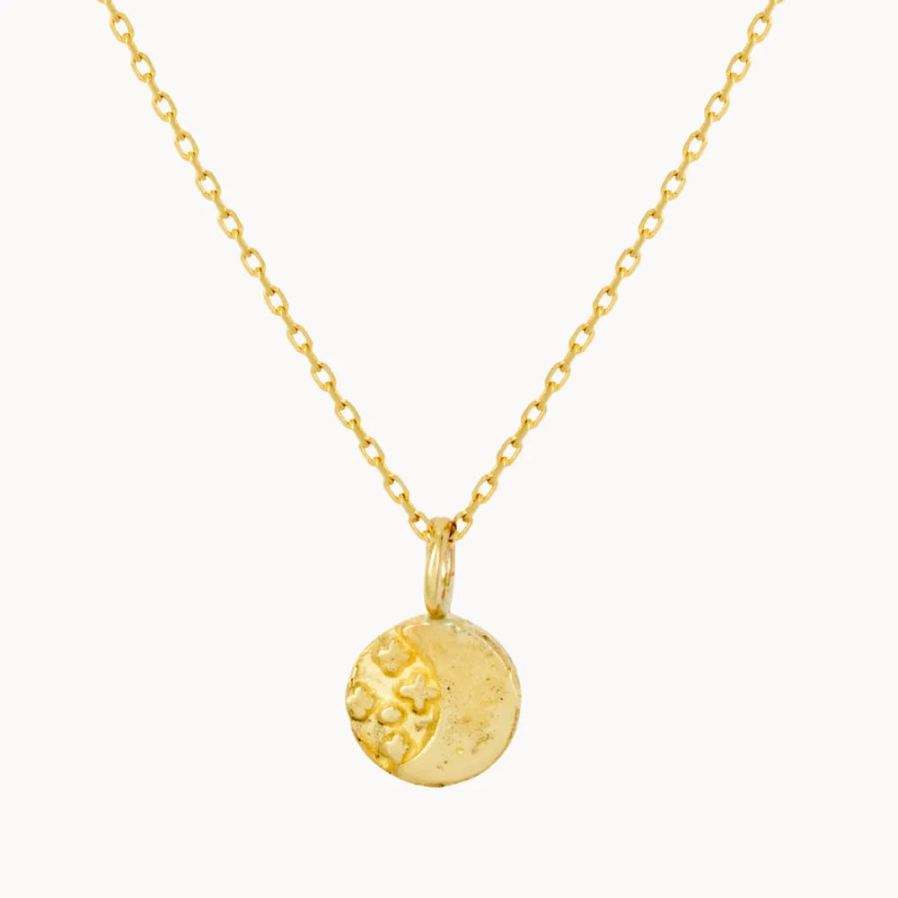 Gold necklace with a round moonlight pendant on a white background