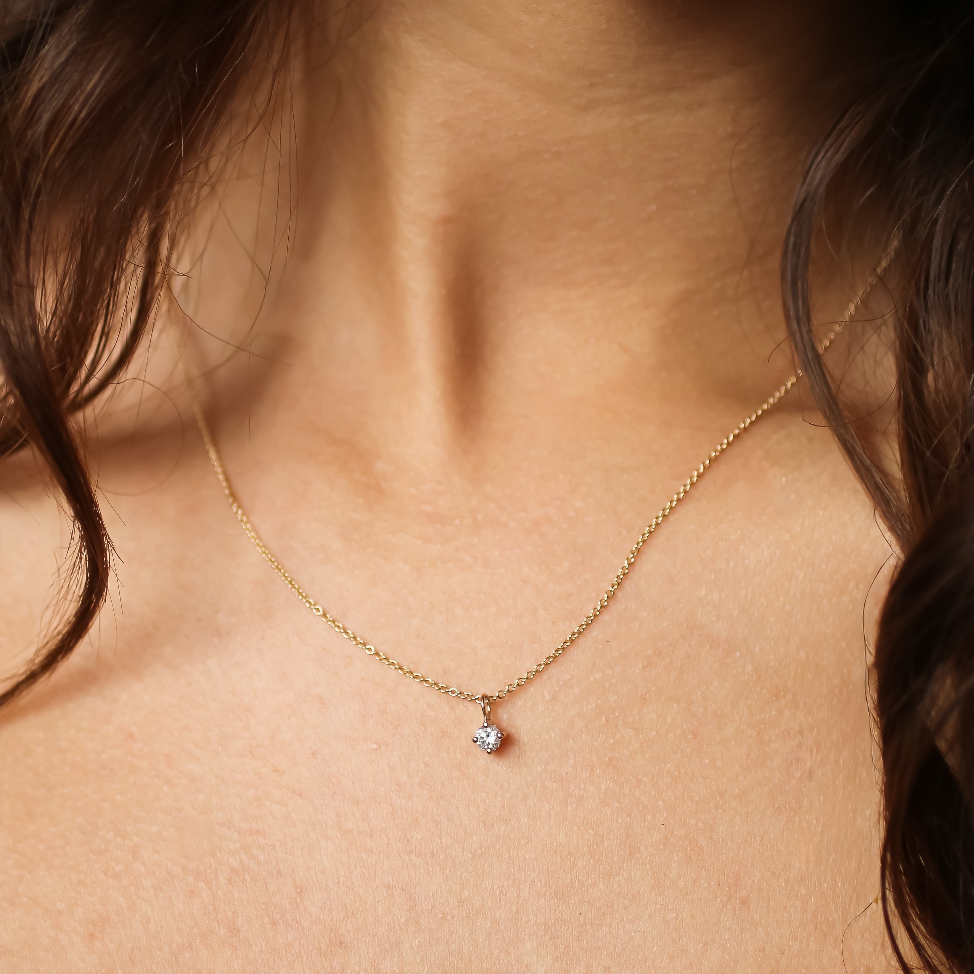 Necklace with a diamond pendant on a person's neck