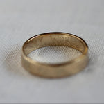 Engraved gold ring with handwritten words 'my world' in capital letters on the inside of the ring
