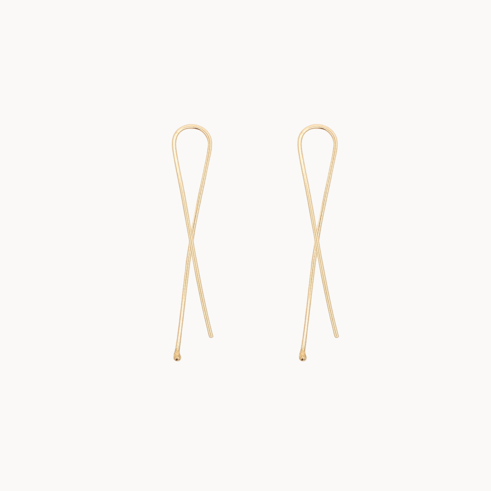 twisted gold earrings on white background