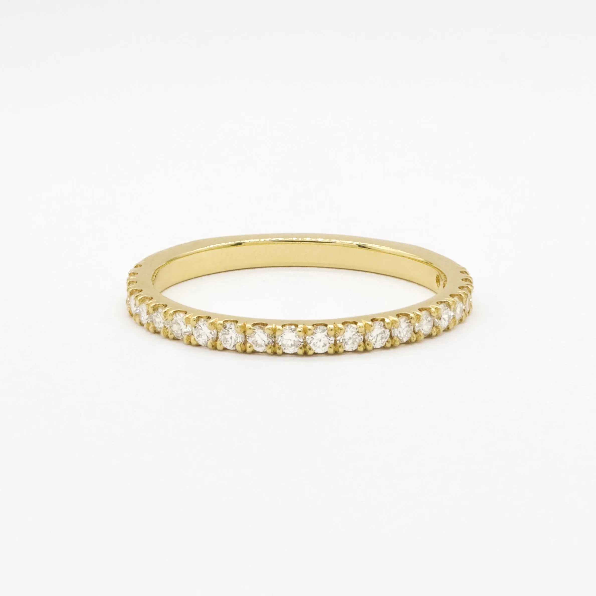Gold eternity wedding ring in 1.6mm width with small diamonds on a white background