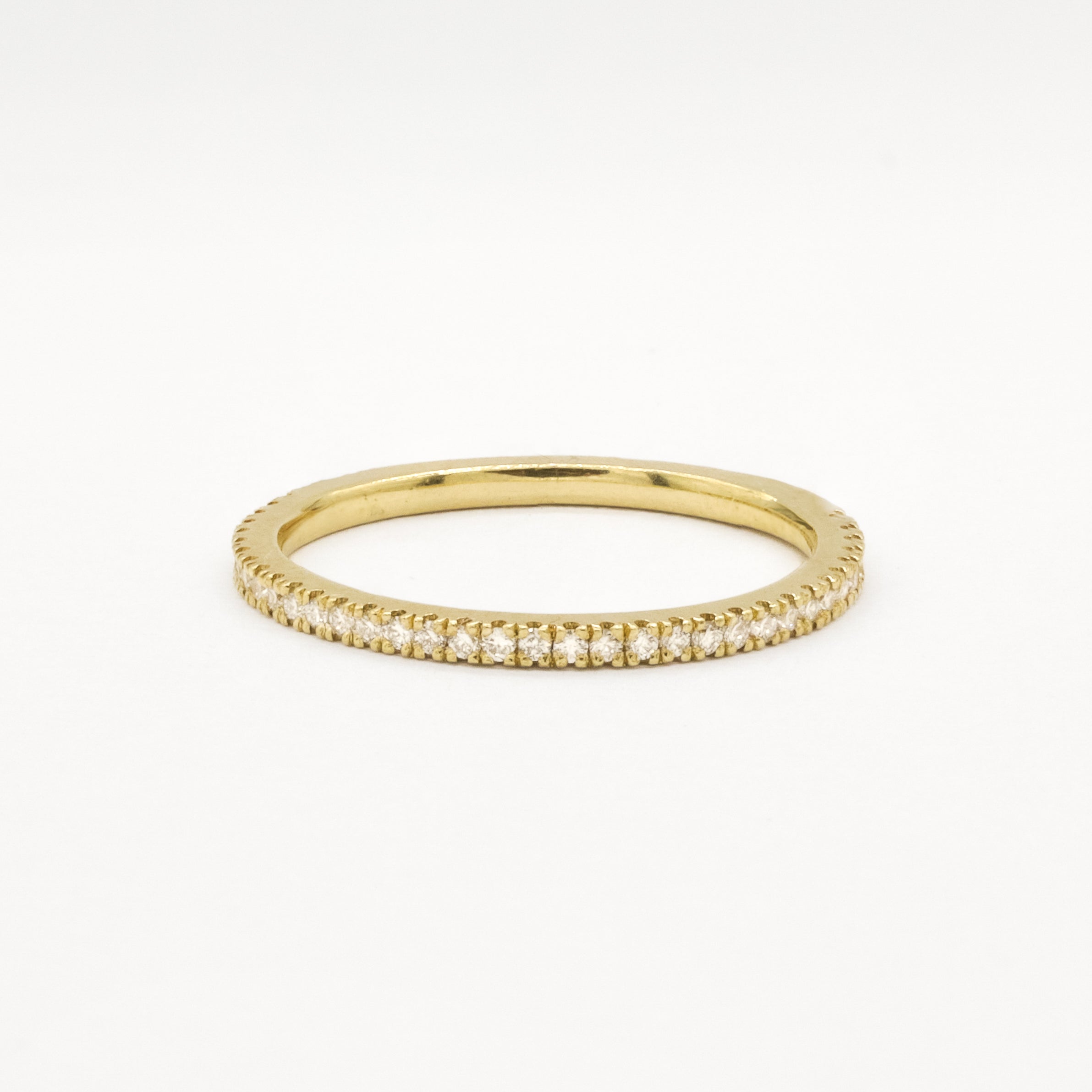 Gold eternity wedding ring with 1mm small diamonds on a white background