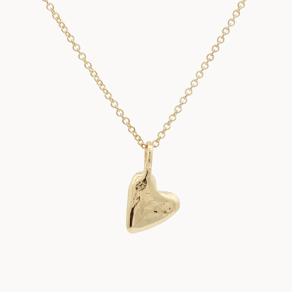 Gold heart-shaped pendant on a chain against a white background