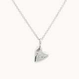 Silver heart-shaped pendant on a chain against a white background