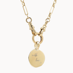 Gold chunky chain necklace with a round pendant engraved 'with love x' on a white background