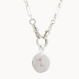 Silver chunky necklace with a round engraved pendant on a white background