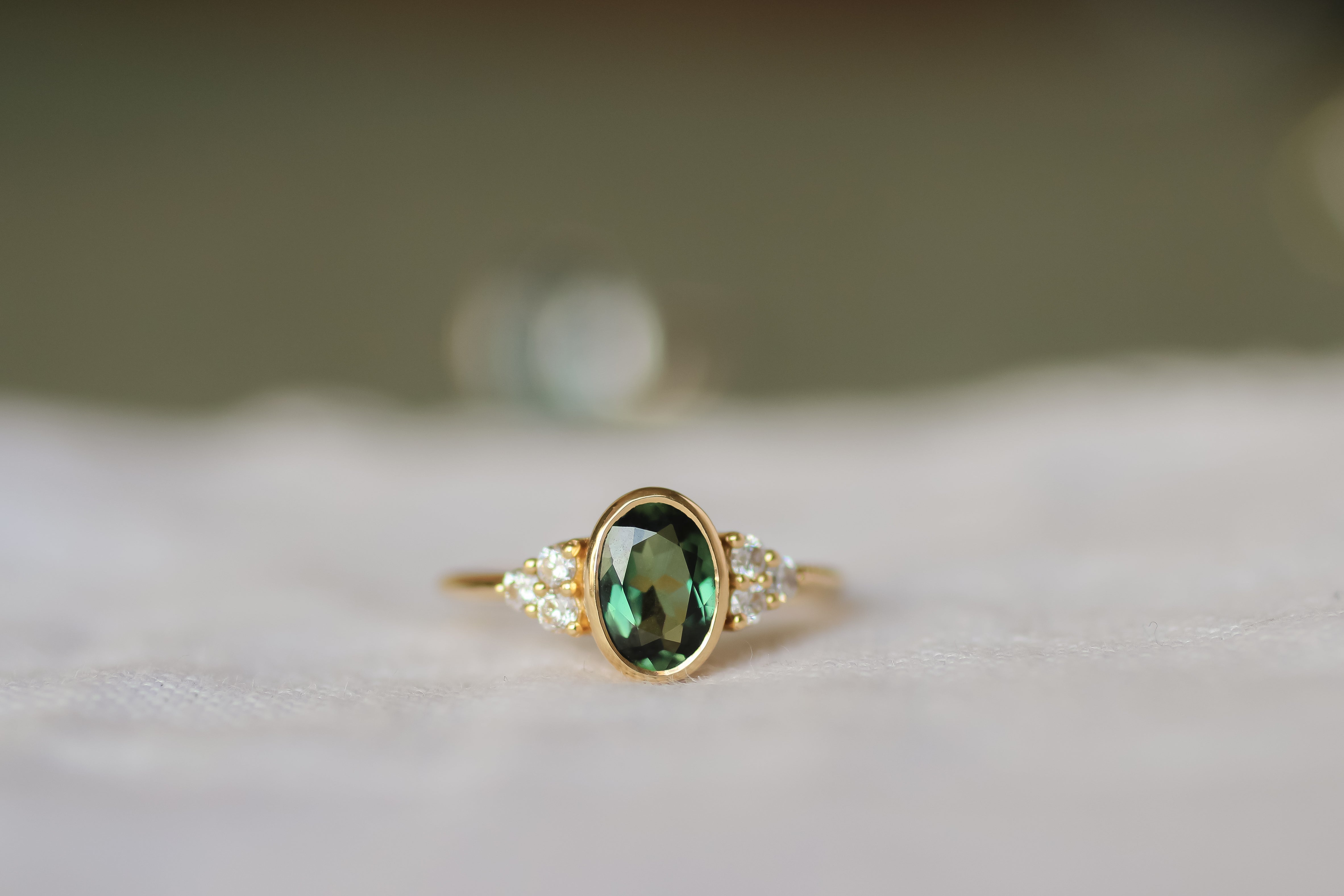 bezel set engagement ring withoval sapphire and prong set diamonds