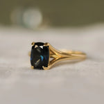 Gold ring with a blue gemstone on a textured surface