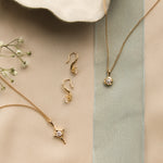 bridal jewellery flatlay with diamond necklaces and hook earrings with ribbon