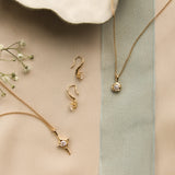 bridal jewellery flatlay with diamond necklaces and hook earrings with ribbon