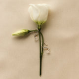 white gold hook earrings with diamonds on a white rose stem against a beige background