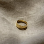 Gold ring on a textured beige fabric background