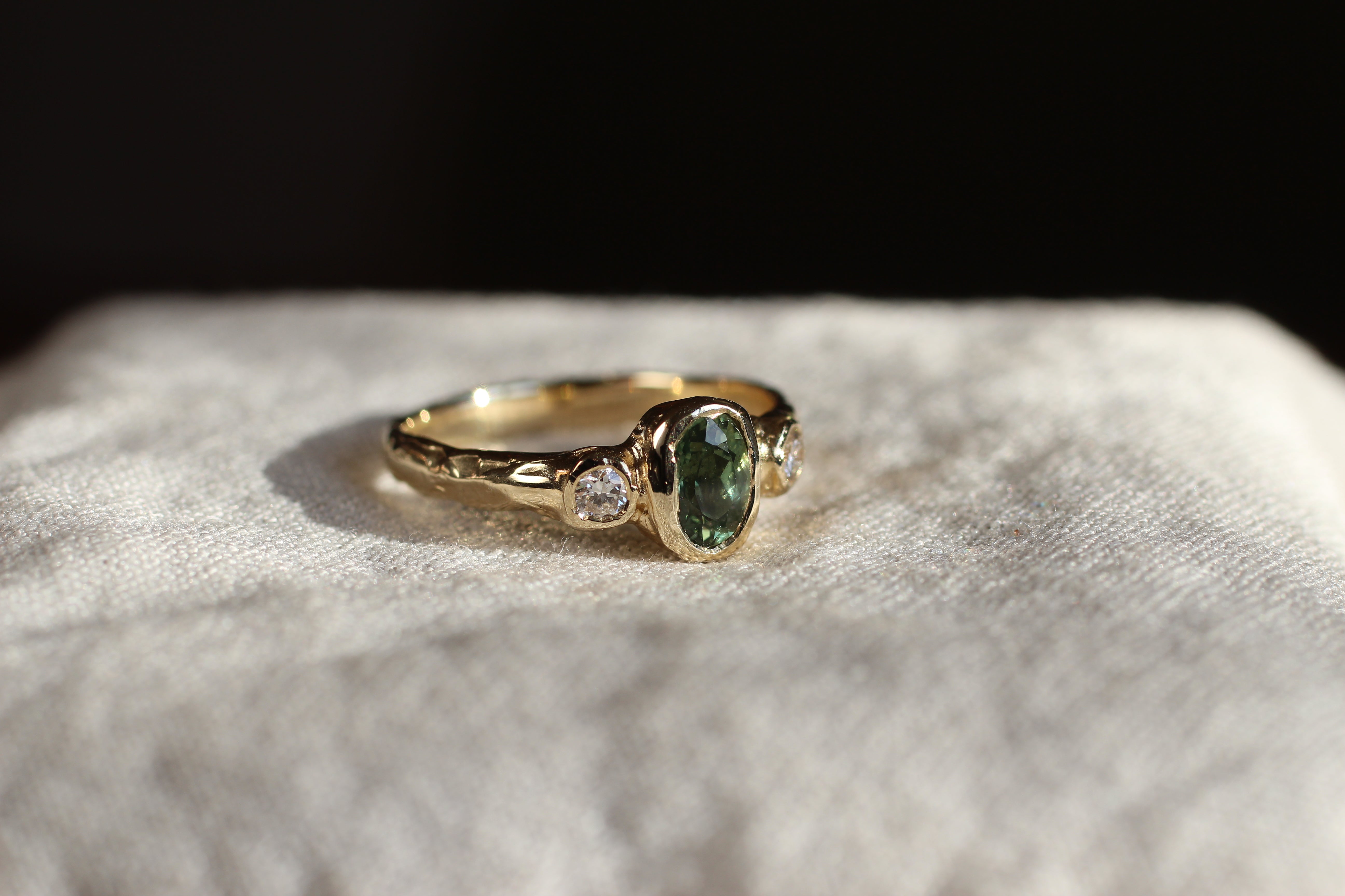 bespoke organic engagement ring with green sapphire and round diamonds