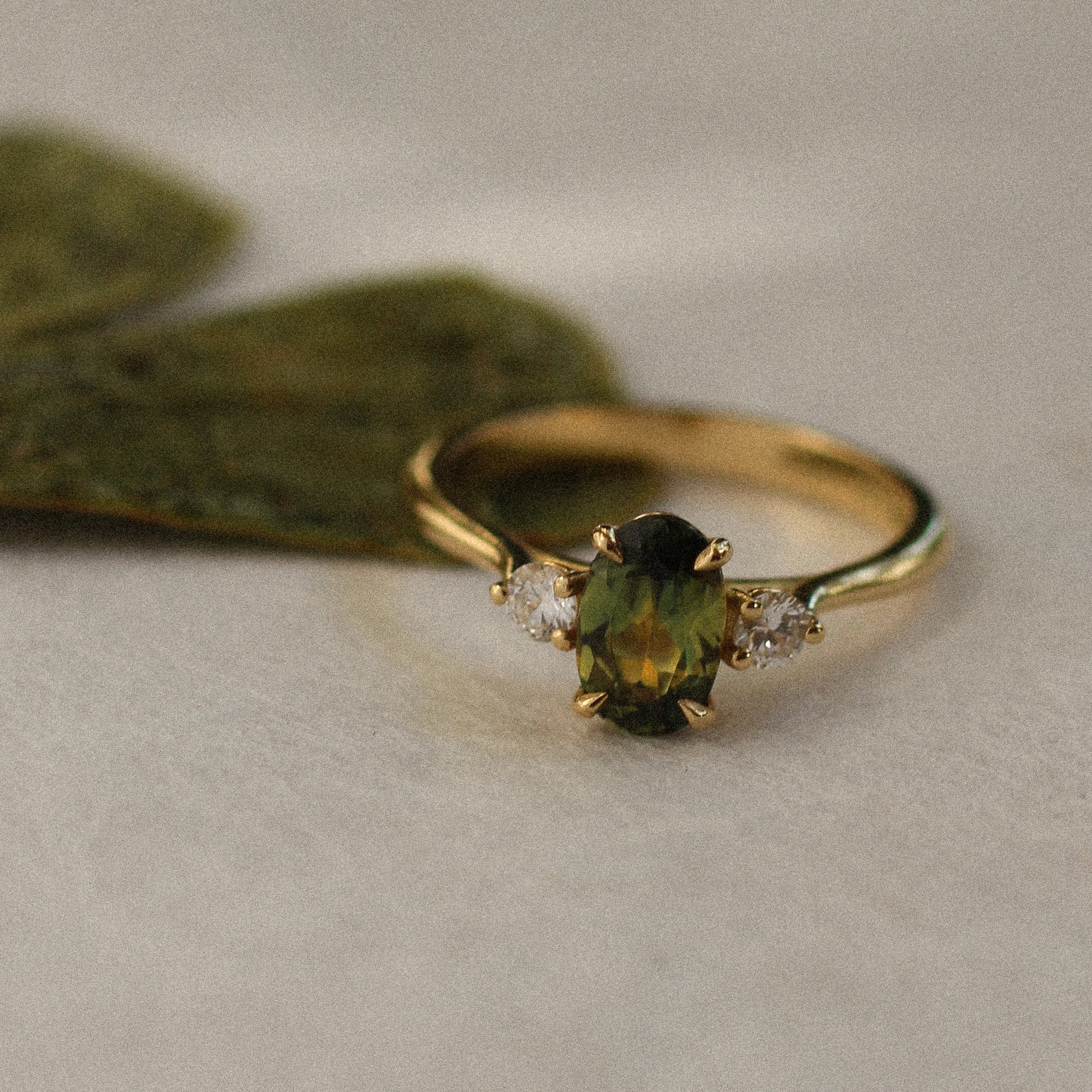 green sapphire trilogy engagement ring with leaf