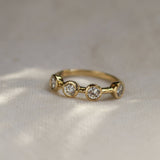 Gold ring with three diamonds on a textured fabric background