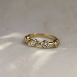 Gold ring with three diamonds on a textured fabric background
