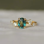 oval sapphire engagement ring with scattered diamonds in a wave formation