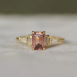 Gold ring with a pink gemstone on a white surface