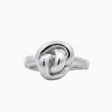 sculptural silver ring with knot design on a white background