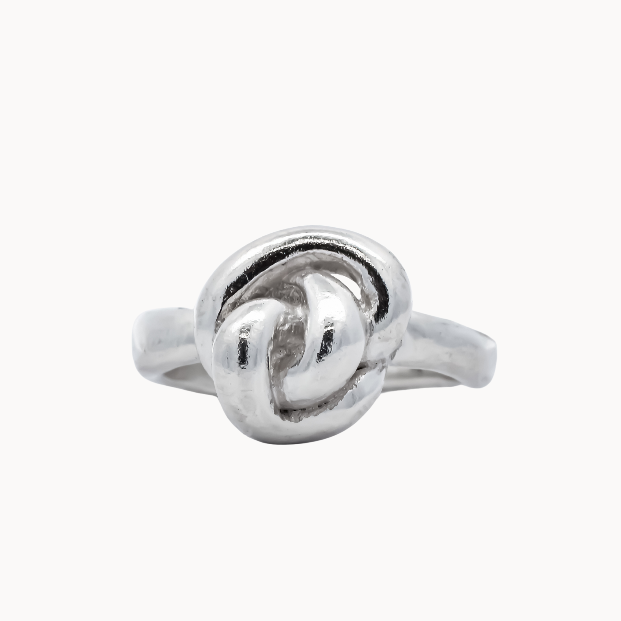 sculptural silver ring with knot design on a white background
