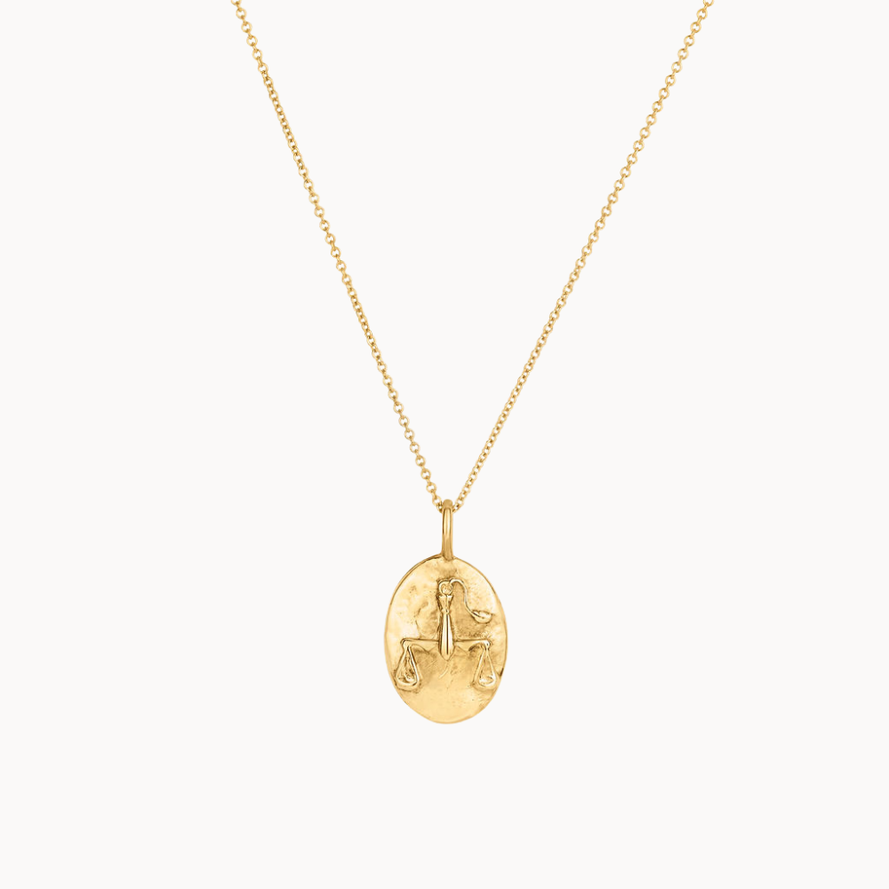Gold libra necklace with a pendant on a white background