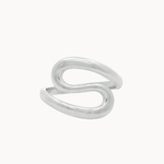 A minimalist silver ring with an organic, flowing S-shaped curve, photographed on a clean, solid off-white background.