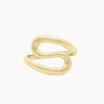 A gold s-shaped ring with a smooth, polished finish, shown on a clean off-white background.