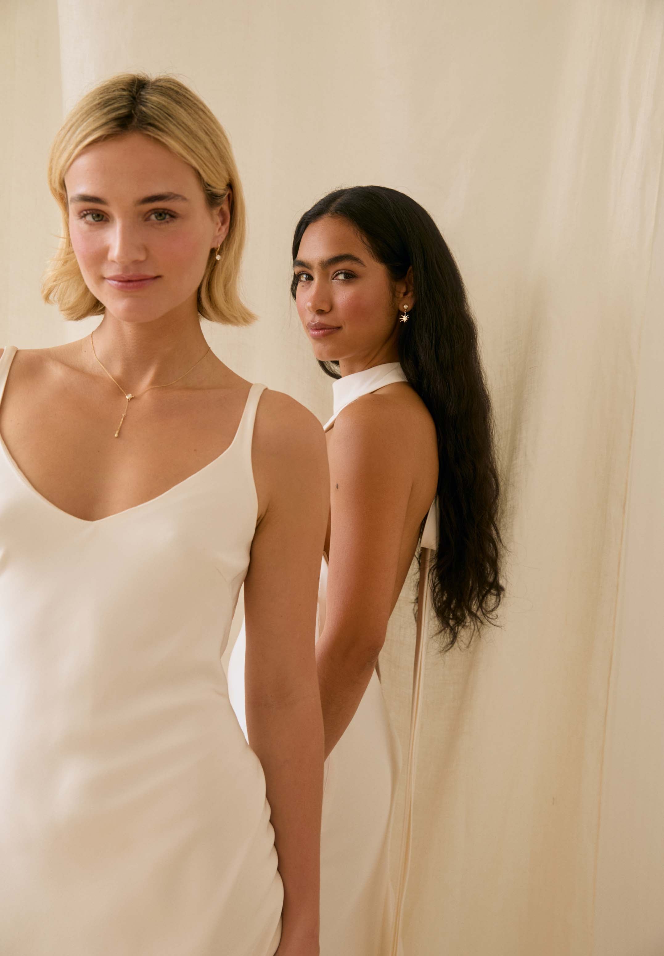 Two women standing side by side against a plain background