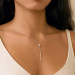 close up of woman wearing white gold diamond necklace with y-shaped drop detail
