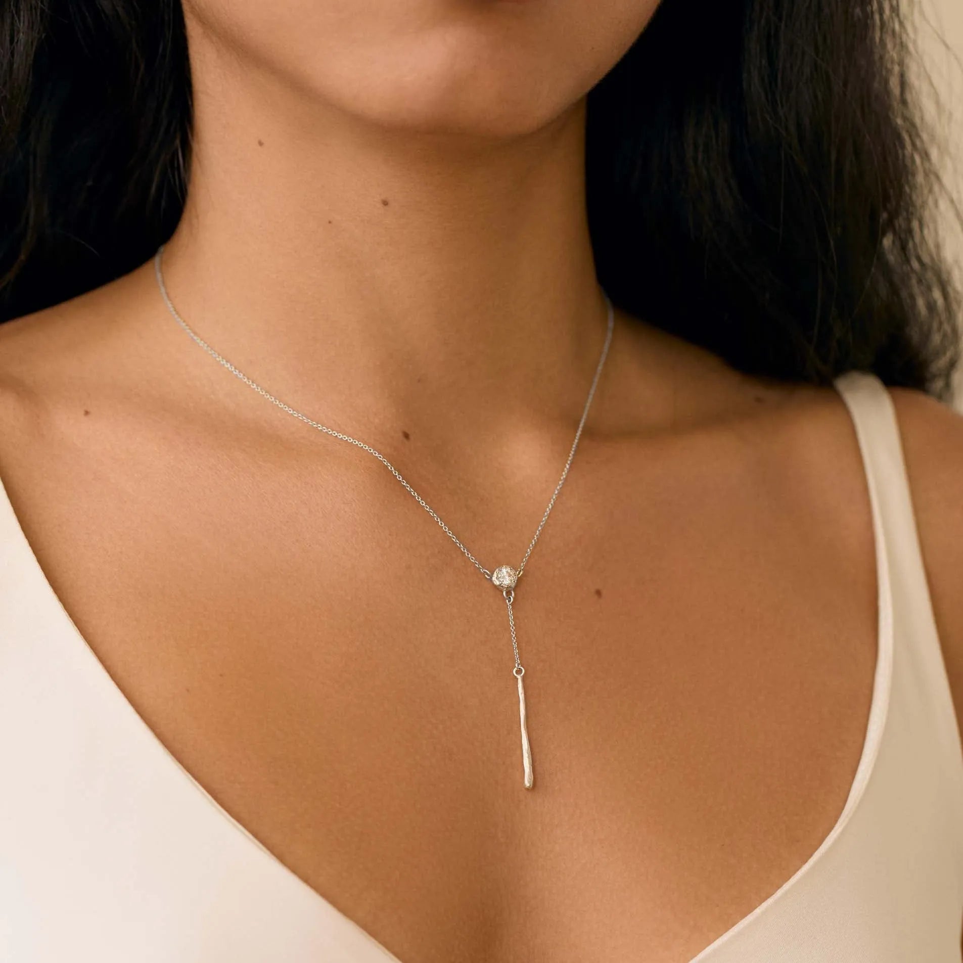 close up of woman wearing white gold diamond necklace with y-shaped drop detail