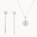 white gold jewelry set with diamond pendant necklace and dangle earrings on a white background