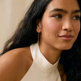 woman wearing halter neck wedding dress and simple gold hook molten drop earrings