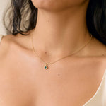 close up of model wearing blue sapphire gold necklace with molten texture
