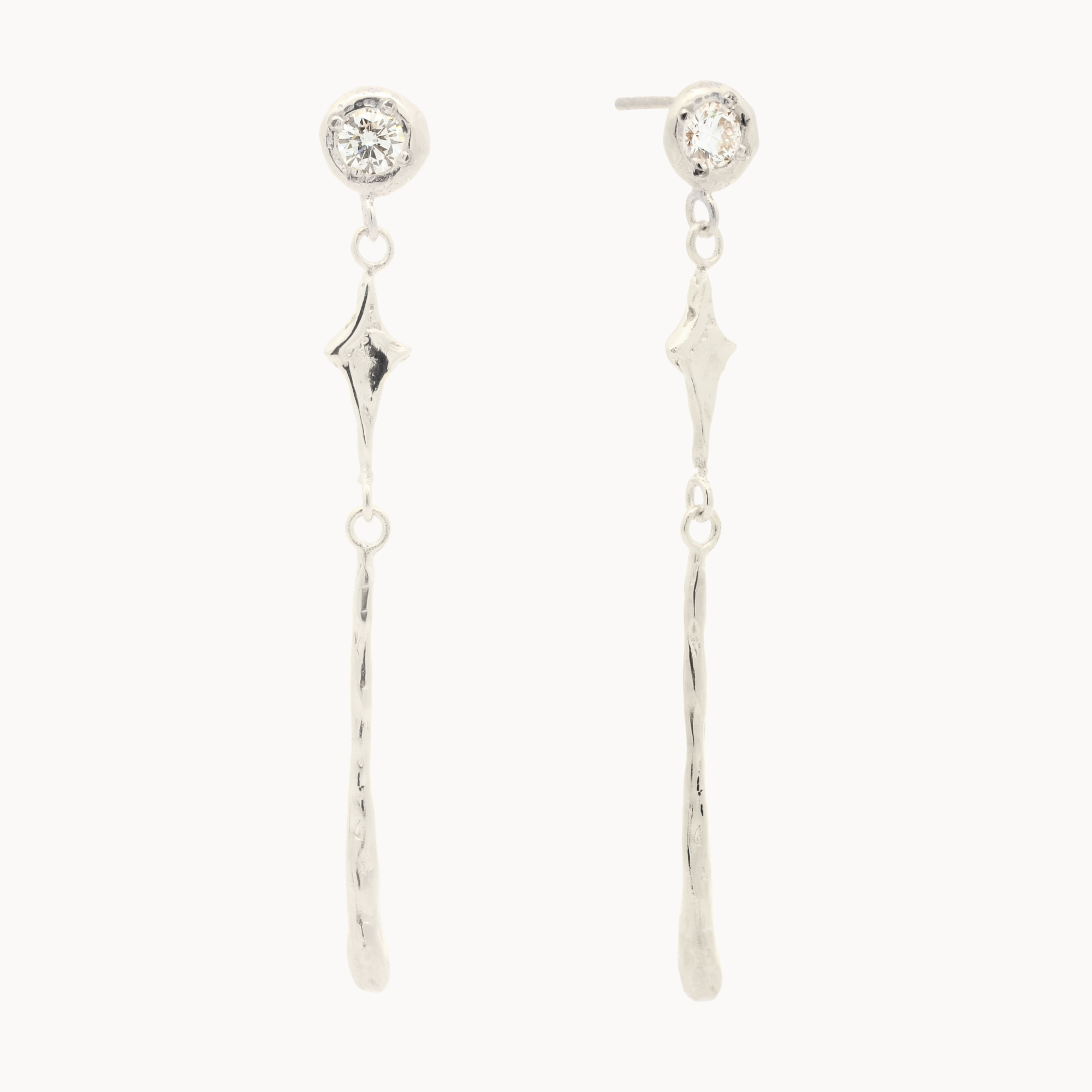 White gold earrings with round diamond stud, star shaped pendant and molten drop detail  on a white background